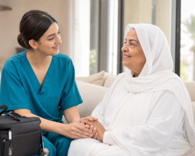 Licensed female home nurse caring for elderly woman in hijab at home in Ajman UAE — Kayan Home Healthcare
